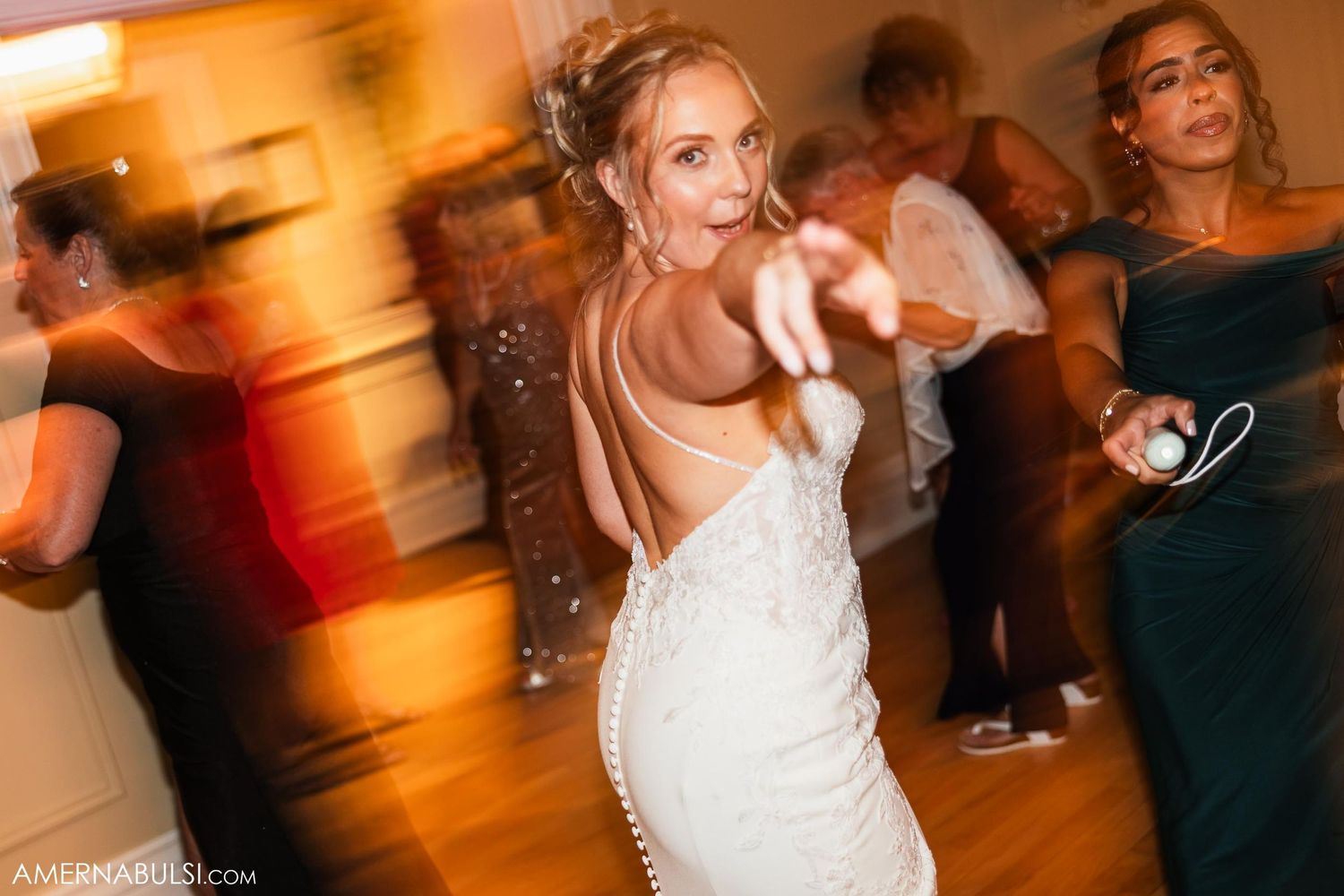 Motion-blurred photo of dancing at wedding reception in formal venue.