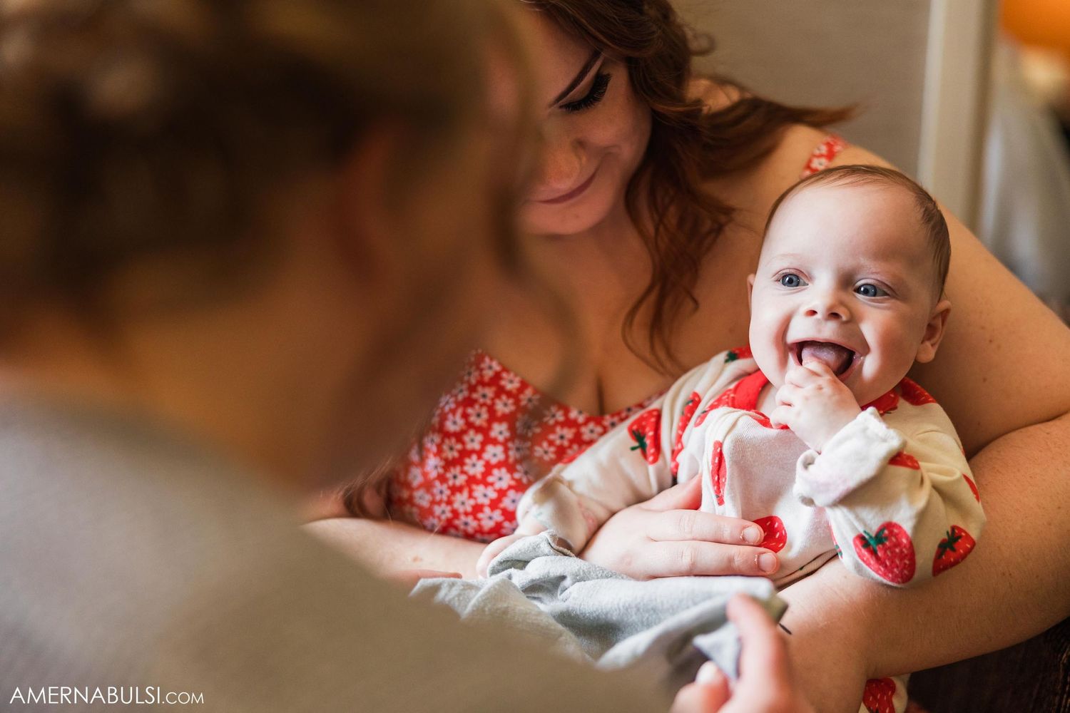 Happy baby smiling while being held during wedding preparations.