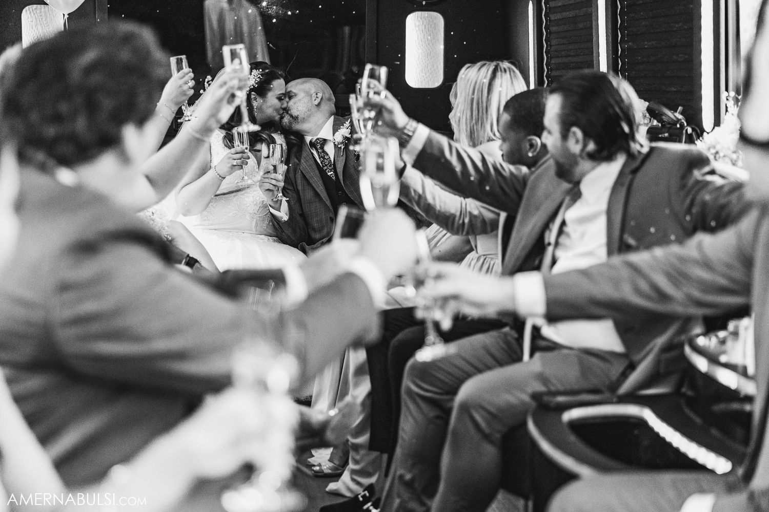 Wedding party toasting with drinks in black and white photography.