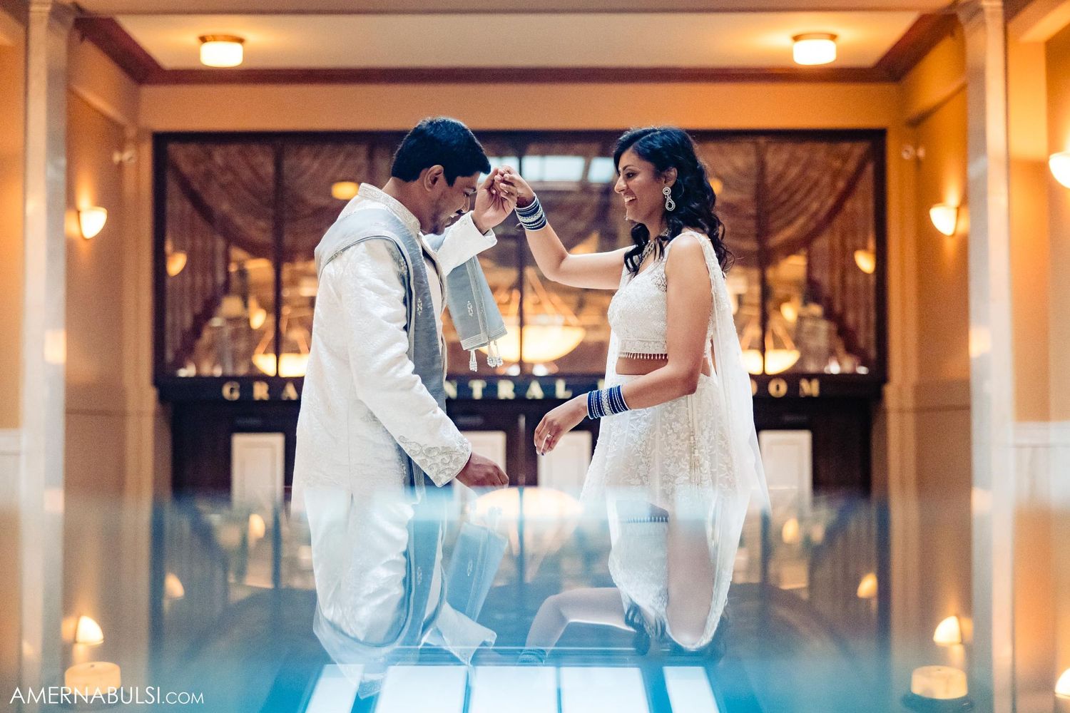 A couple shares an emotional moment during their wedding ceremony in an elegantly lit indoor space.