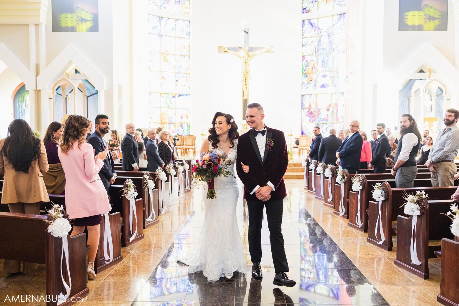 Traditional church wedding ceremony with guests seated in wooden pews under vaulted ceilings.
