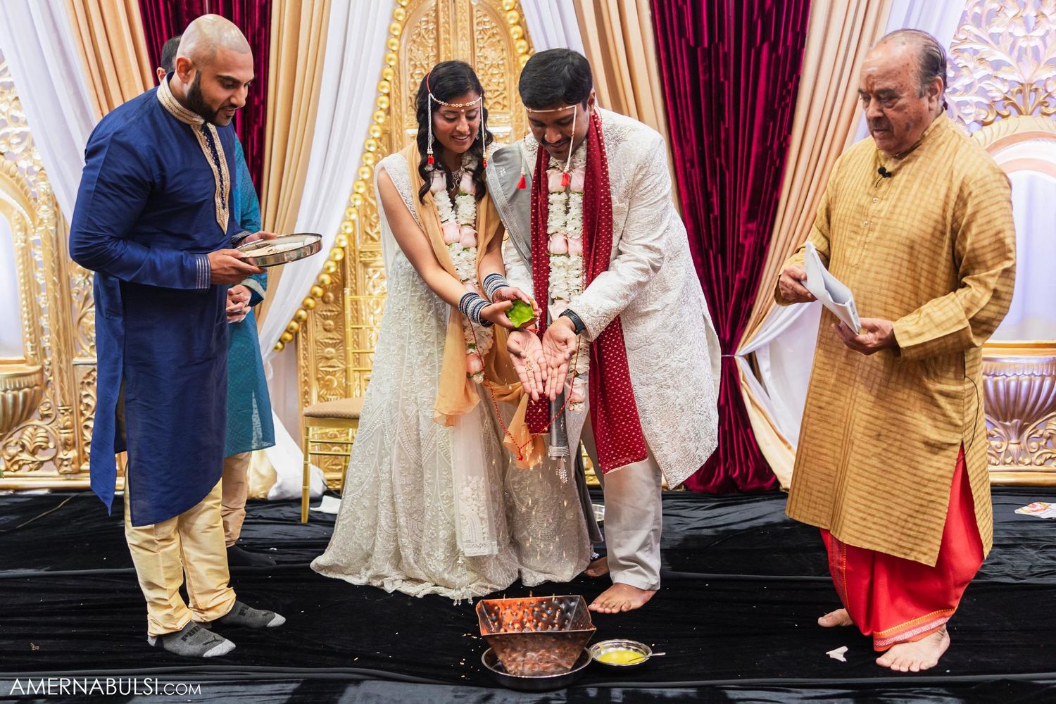 Wedding ceremony participants perform traditional Indian rituals around sacred fire altar.