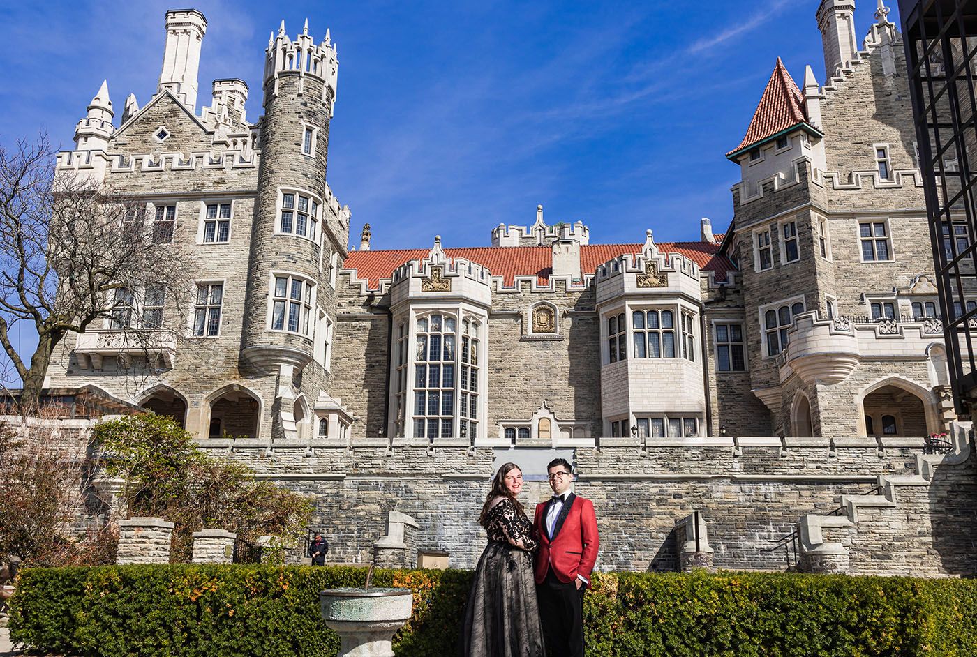 Gothic stone castle with towers and ornate architecture against bright blue sky.
