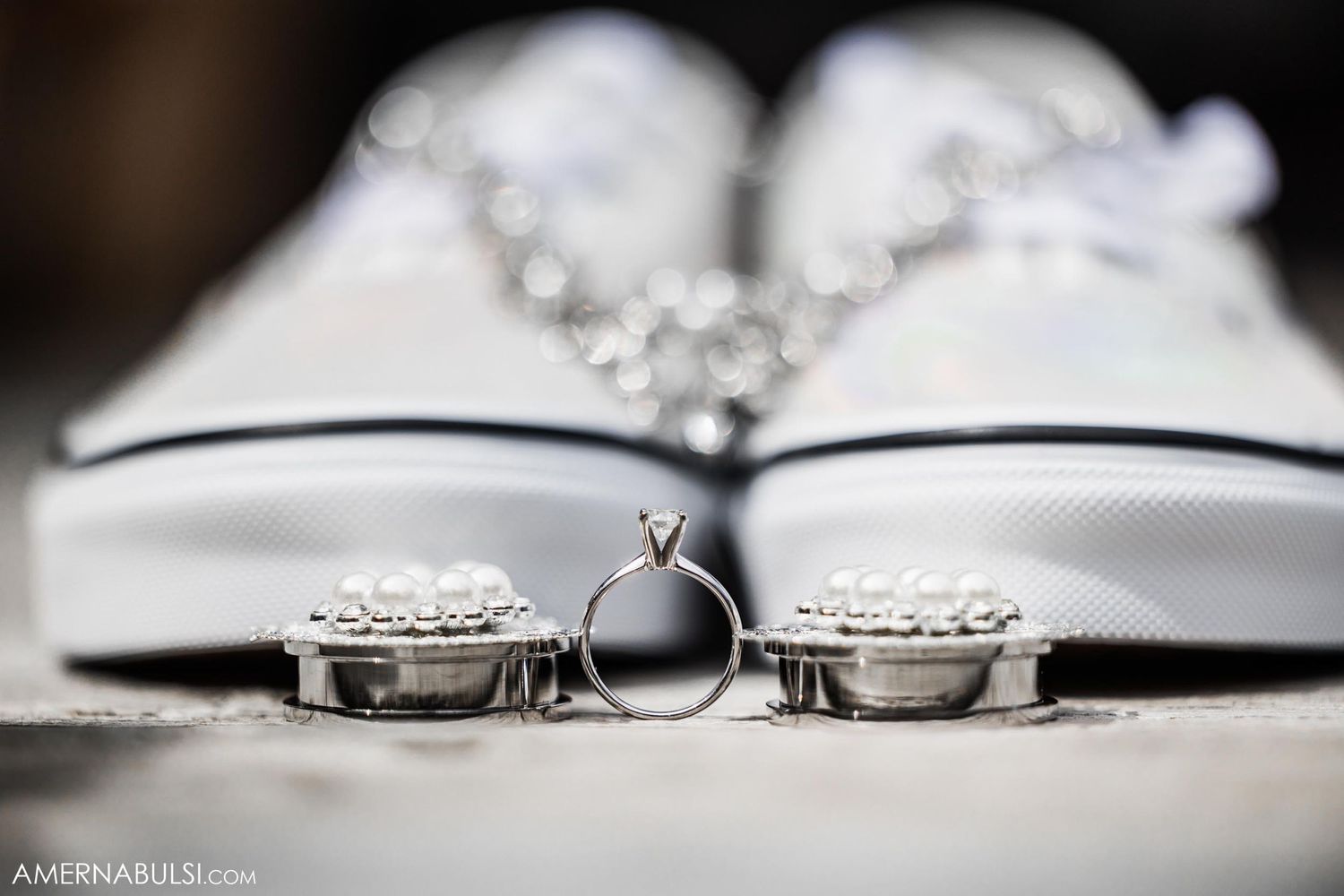 Wedding ring and engagement rings artistically placed on white sneakers.