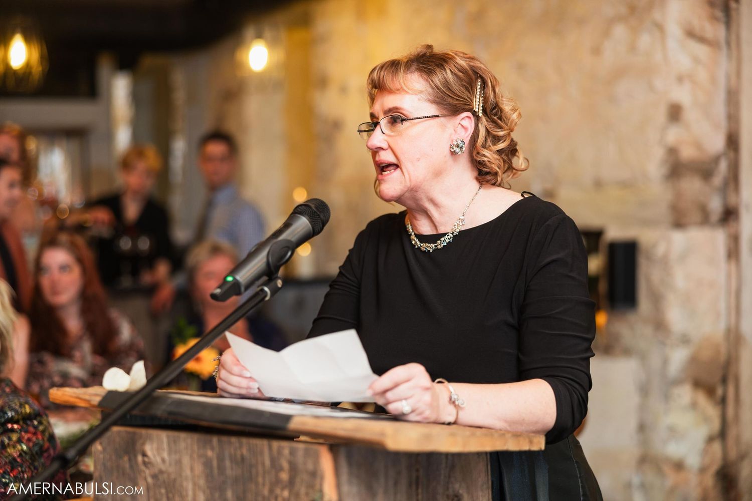 A speaker delivering an emotional speech at a wedding reception.