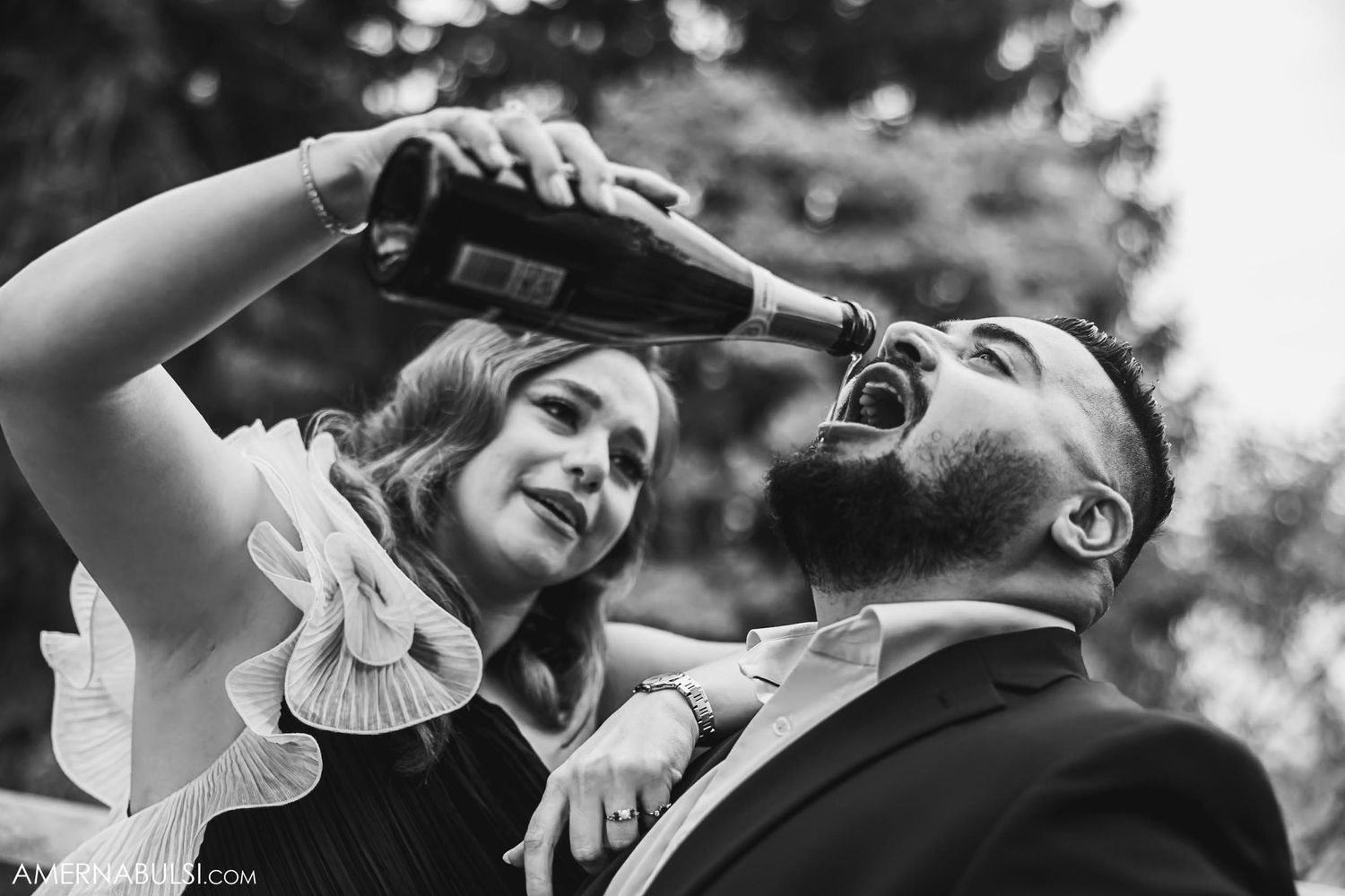 A playful moment of two people sharing champagne during a celebration.