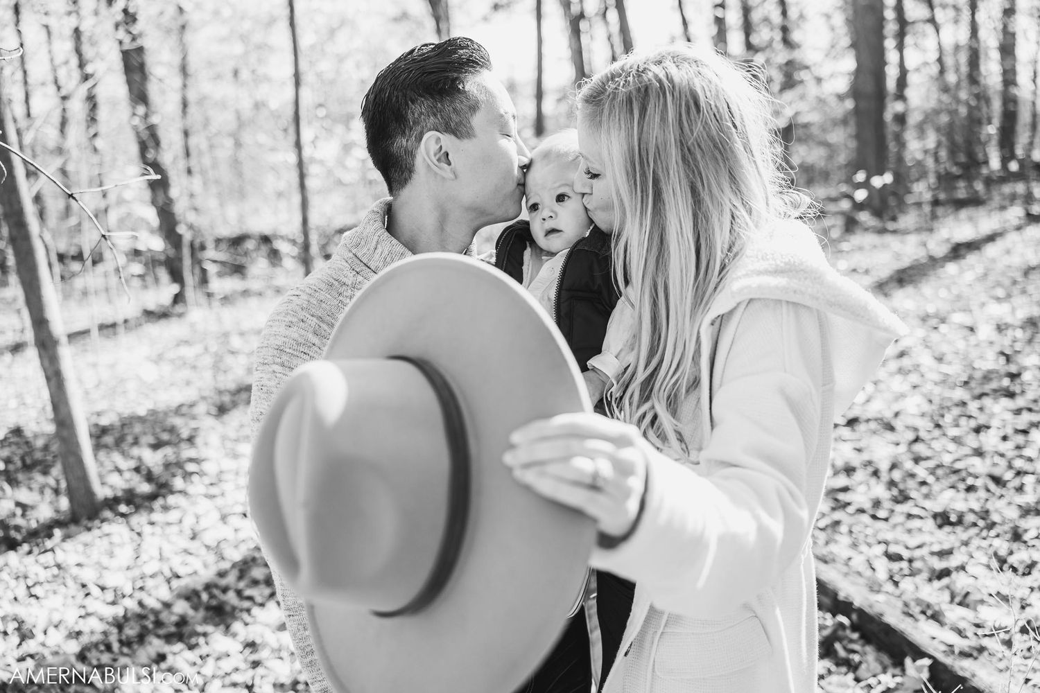 Close-up black and white photo of romantic moment between couple with wide-brimmed hat.