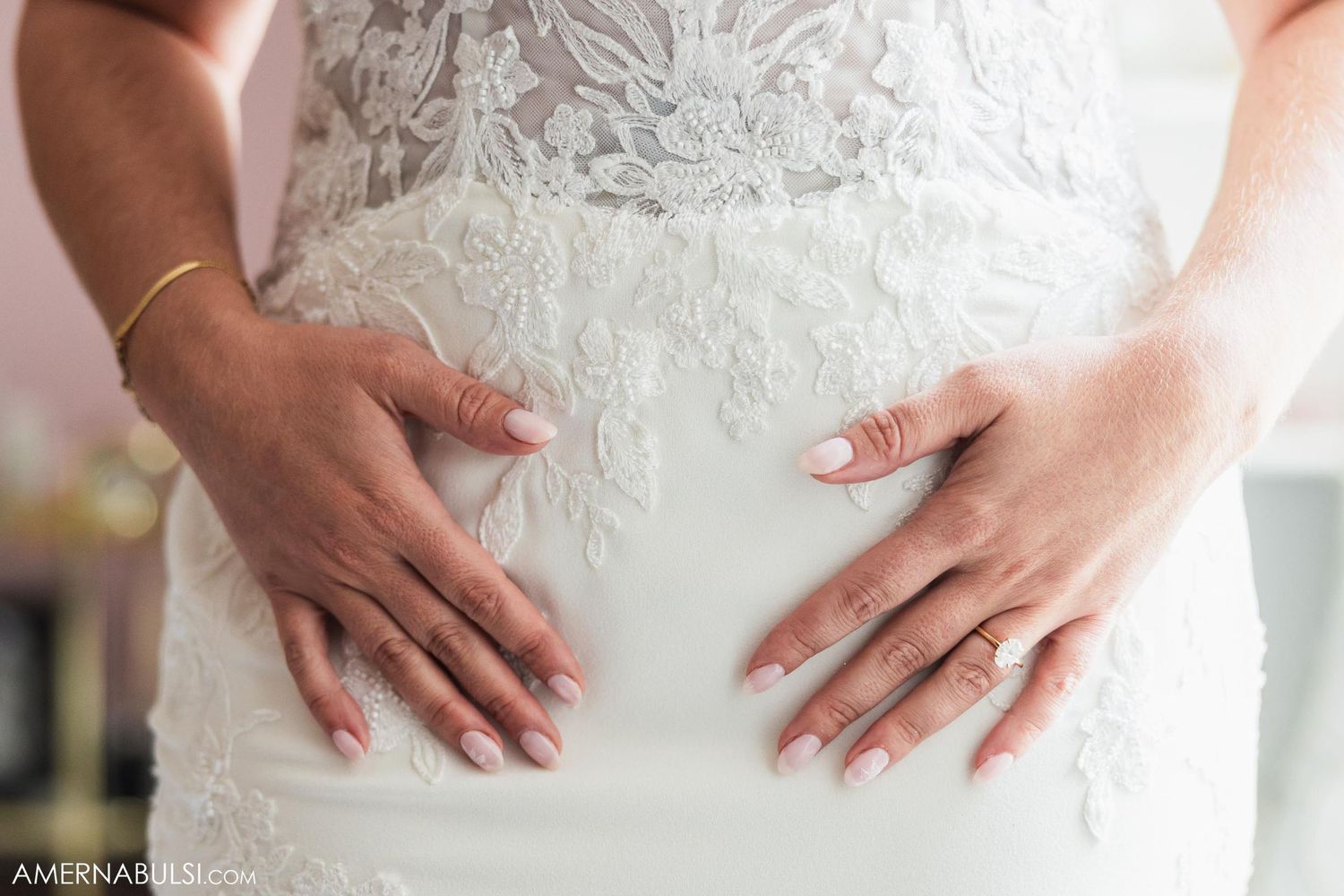 Close-up detail shot of delicate lace and beading on white wedding dress bodice.