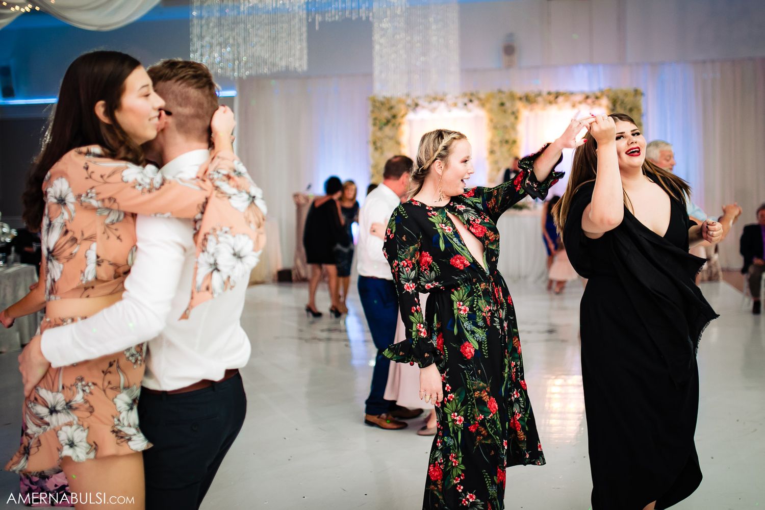 Wedding reception guests dancing and celebrating with enthusiasm on the dance floor.