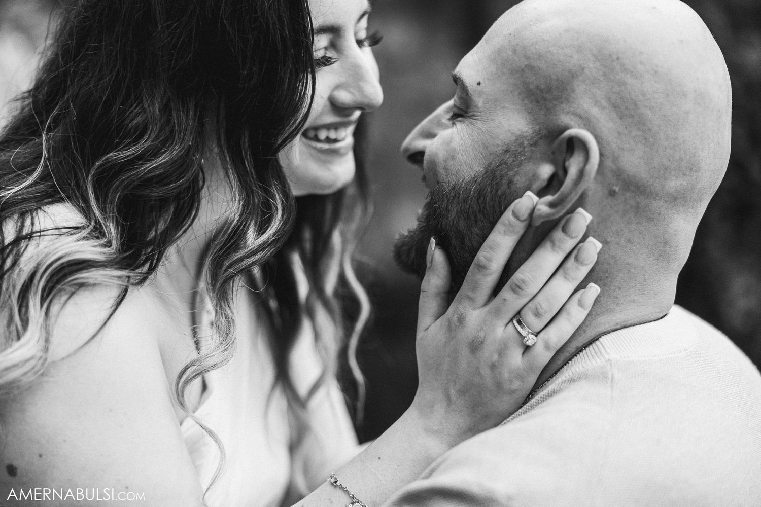 Close-up black and white portrait of couple sharing an intimate moment outdoors.