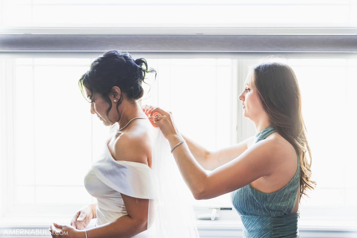 Individuals getting ready in a bright white room during wedding preparations.
