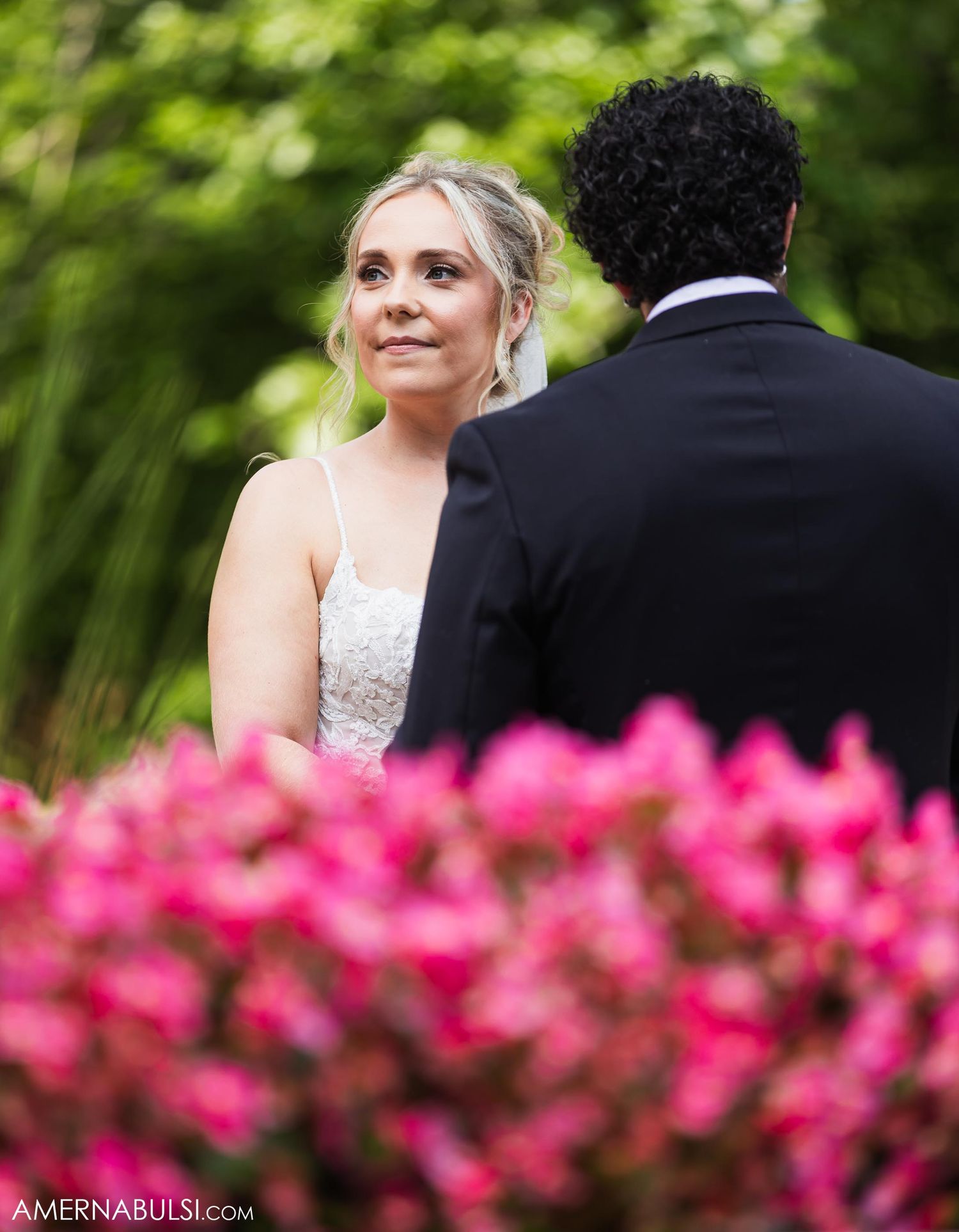 Beautiful outdoor wedding scene with vibrant pink flowers in the foreground.