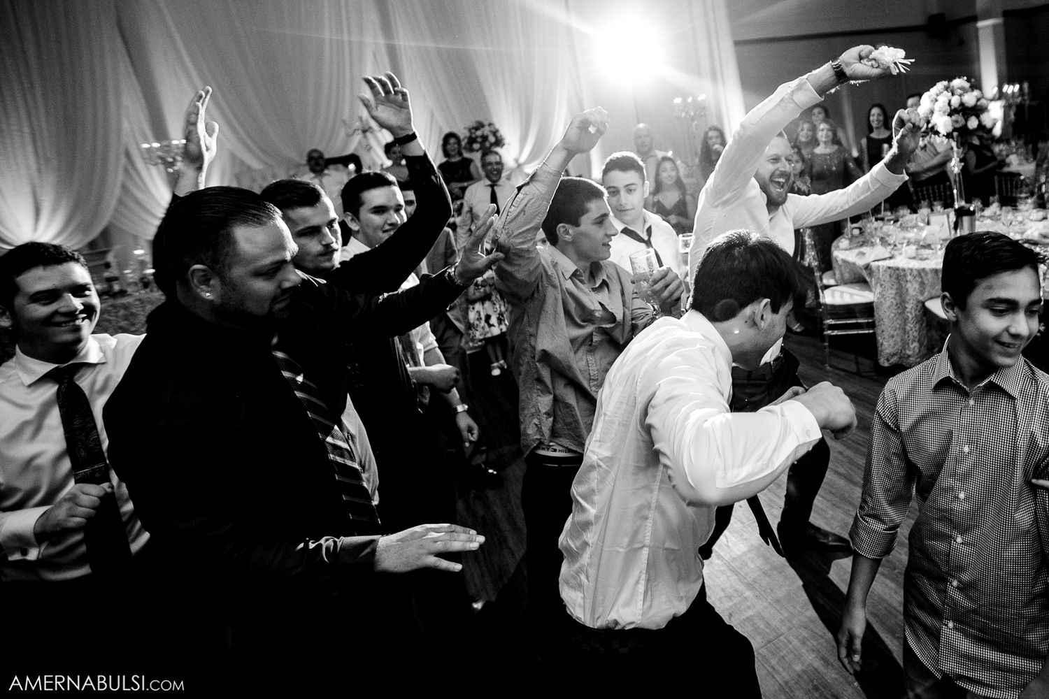 Black and white wedding reception photos show guests dancing and celebrating with joyful expressions on the dance floor.