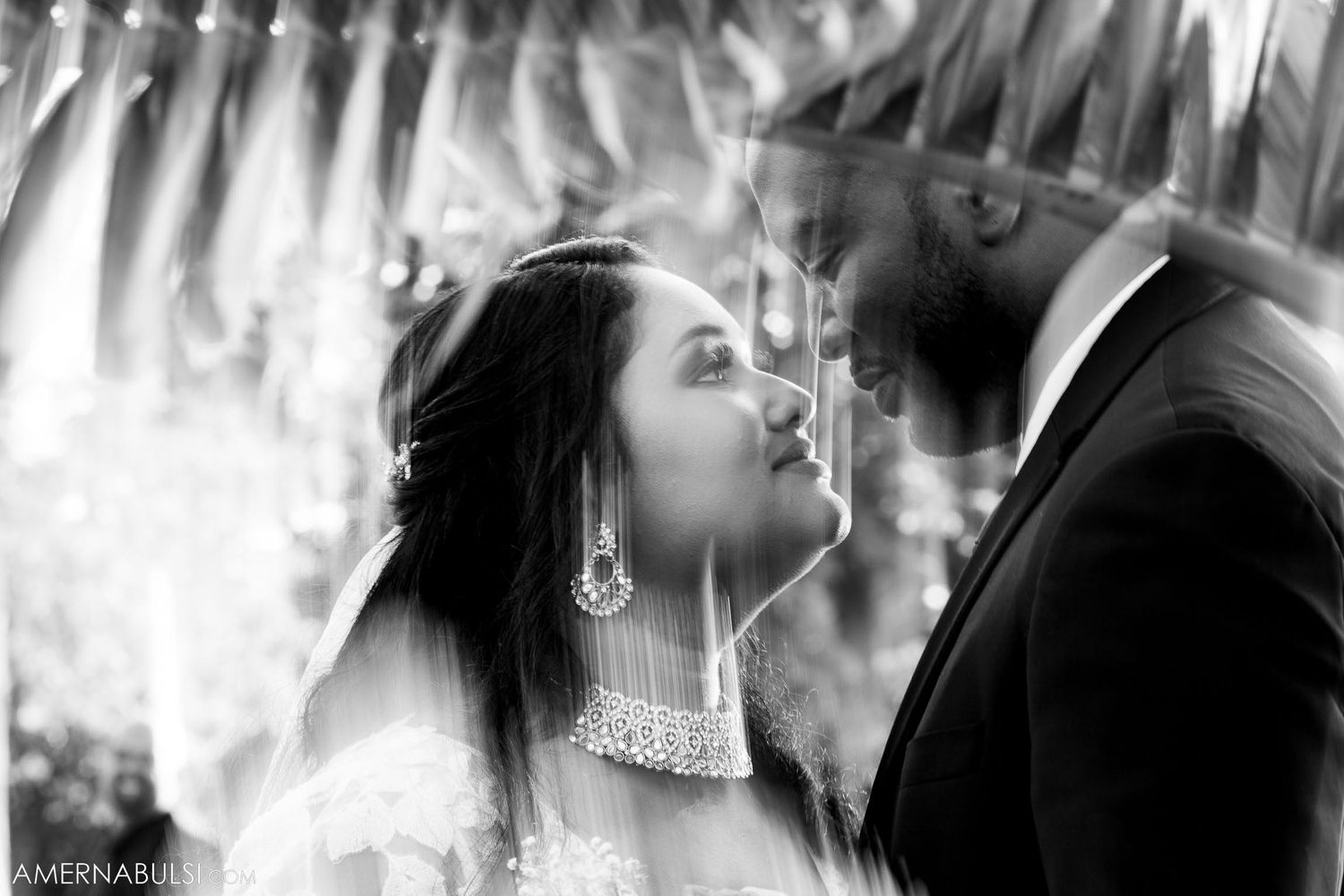 An intimate black and white wedding portrait showing a tender moment between newlyweds.