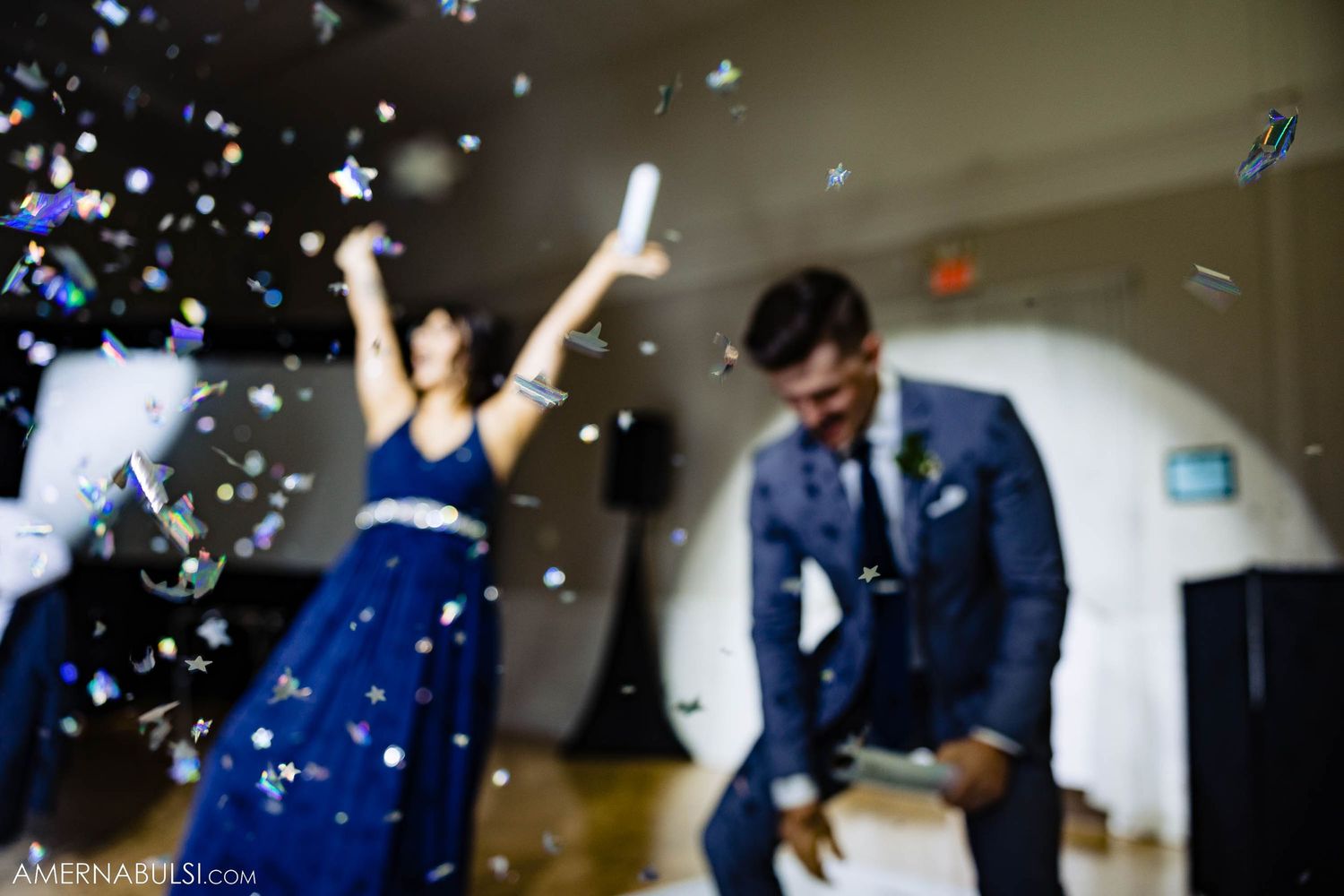Confetti falls as wedding party members dance and celebrate during reception finale.