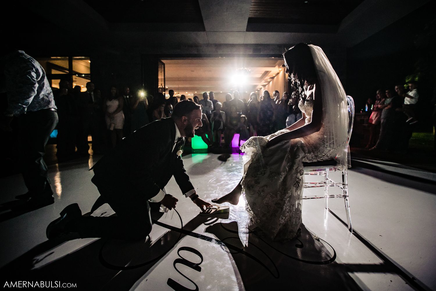 Dramatic silhouettes of party guests dancing in a dimly lit venue.