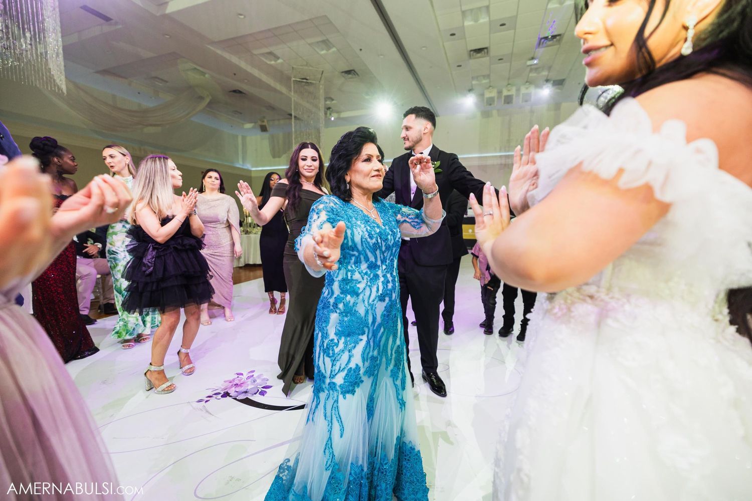Wedding reception dance floor with guests in formal attire enjoying celebration.