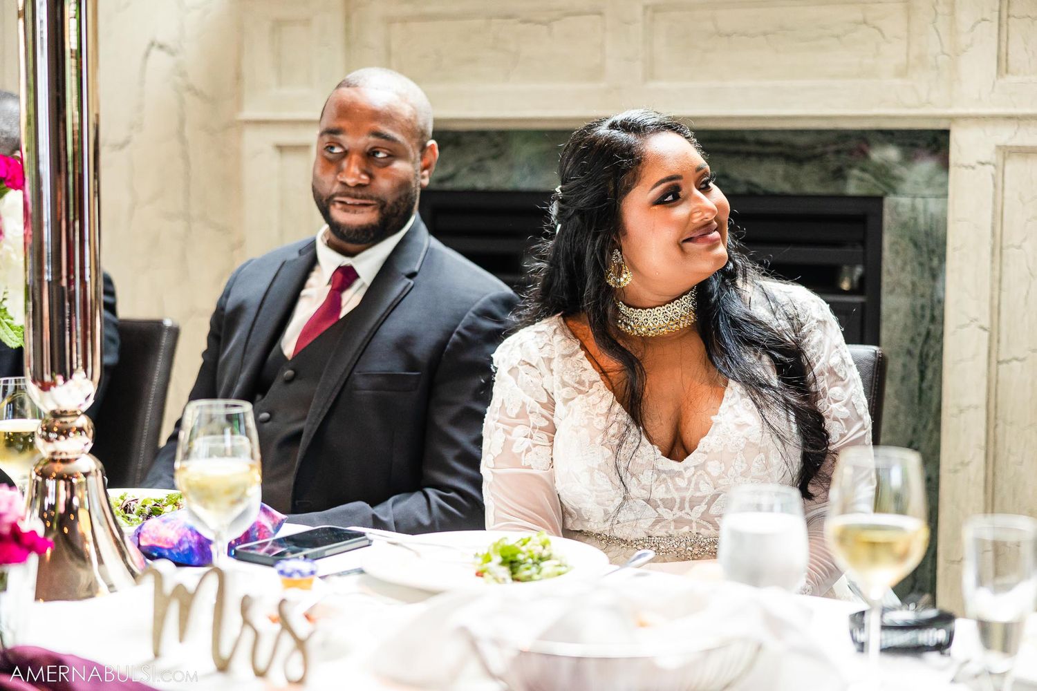 Couple sharing a joyful moment at their reception table.