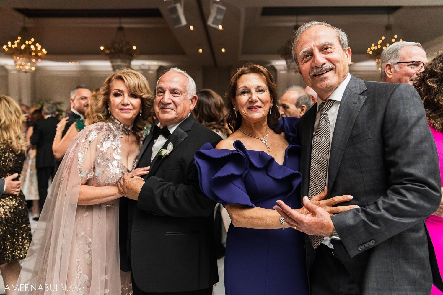Elegant wedding reception guests in formal attire enjoying the celebration together.