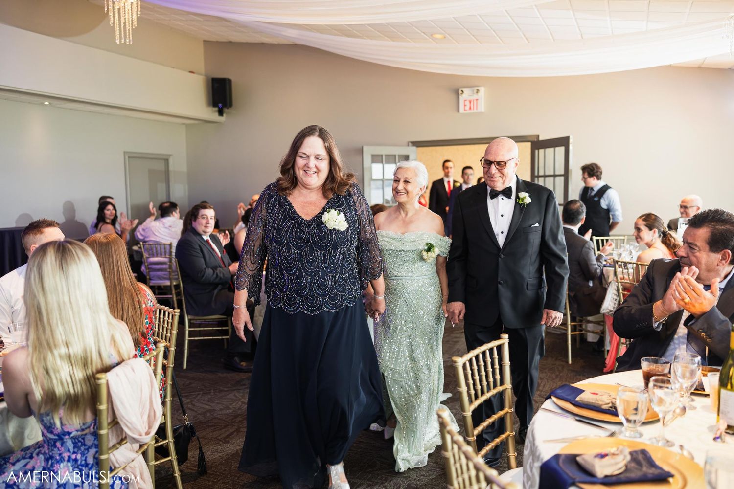 Wedding guests make celebratory entrance into reception dining room.