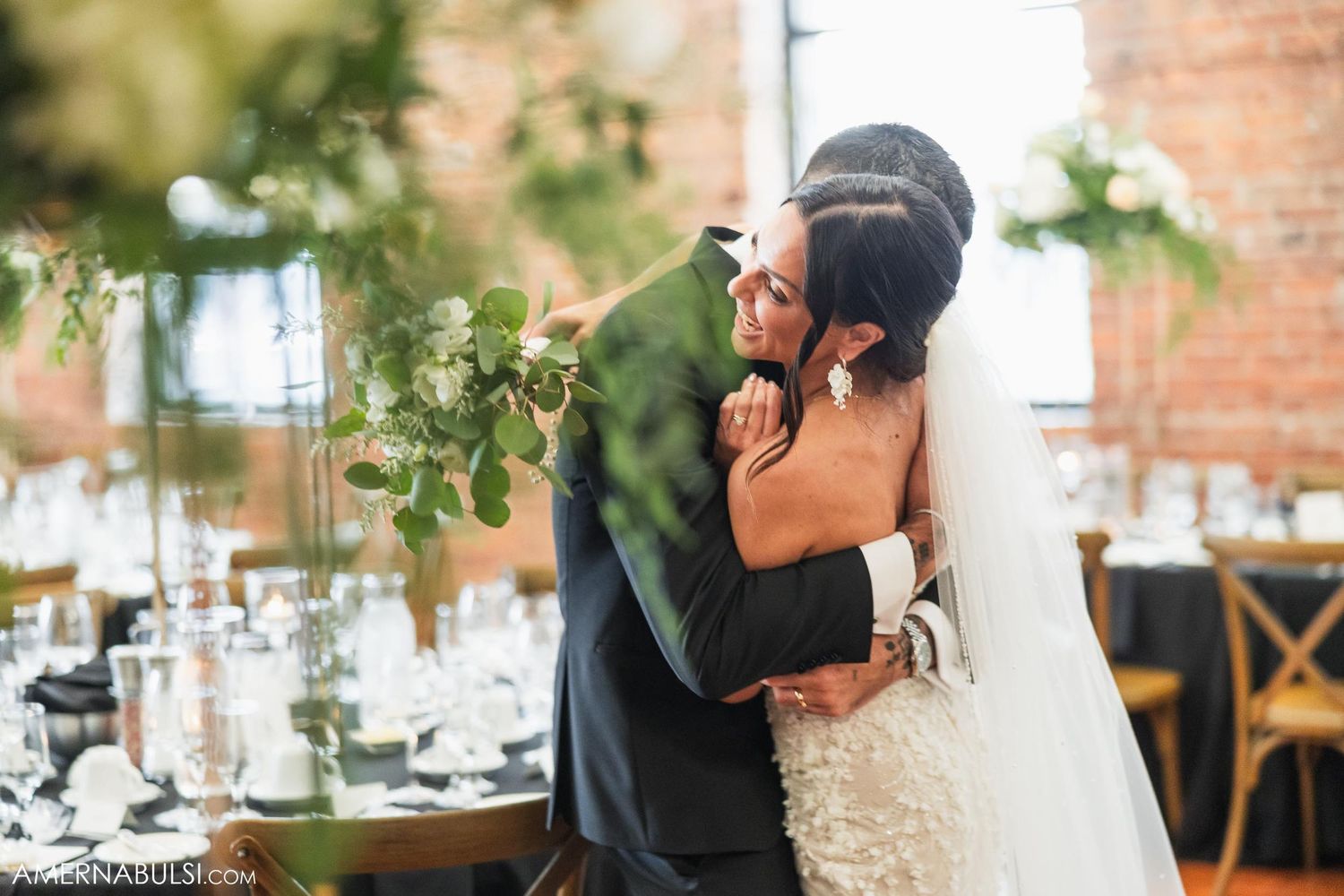 An intimate embrace between newlyweds in a beautifully decorated reception venue.