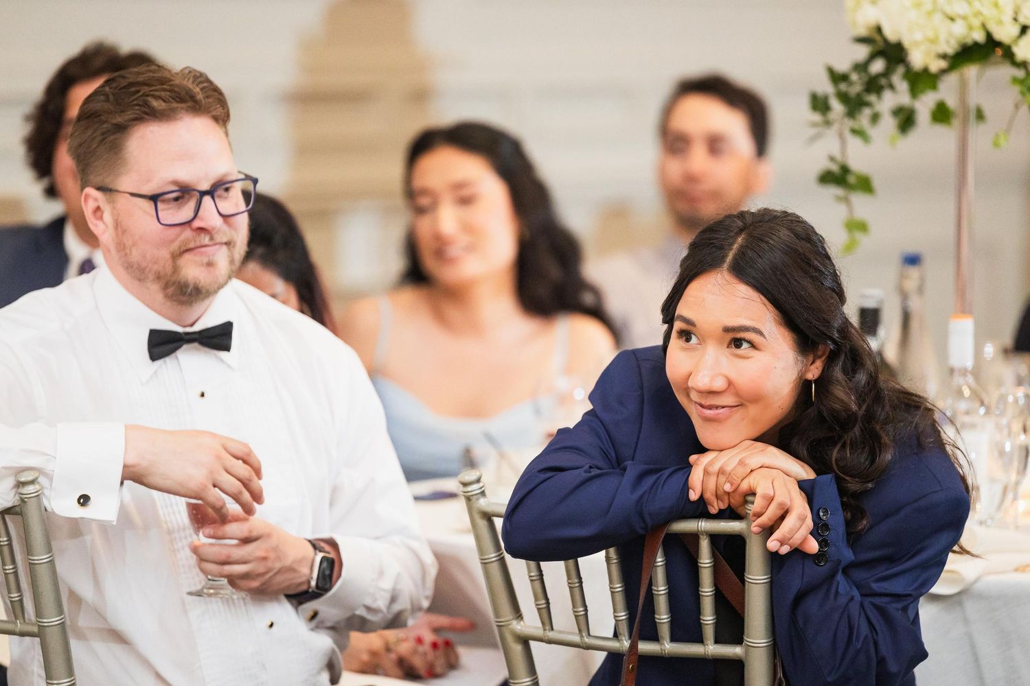 Wedding guests enjoying conversation at an elegant reception dinner.