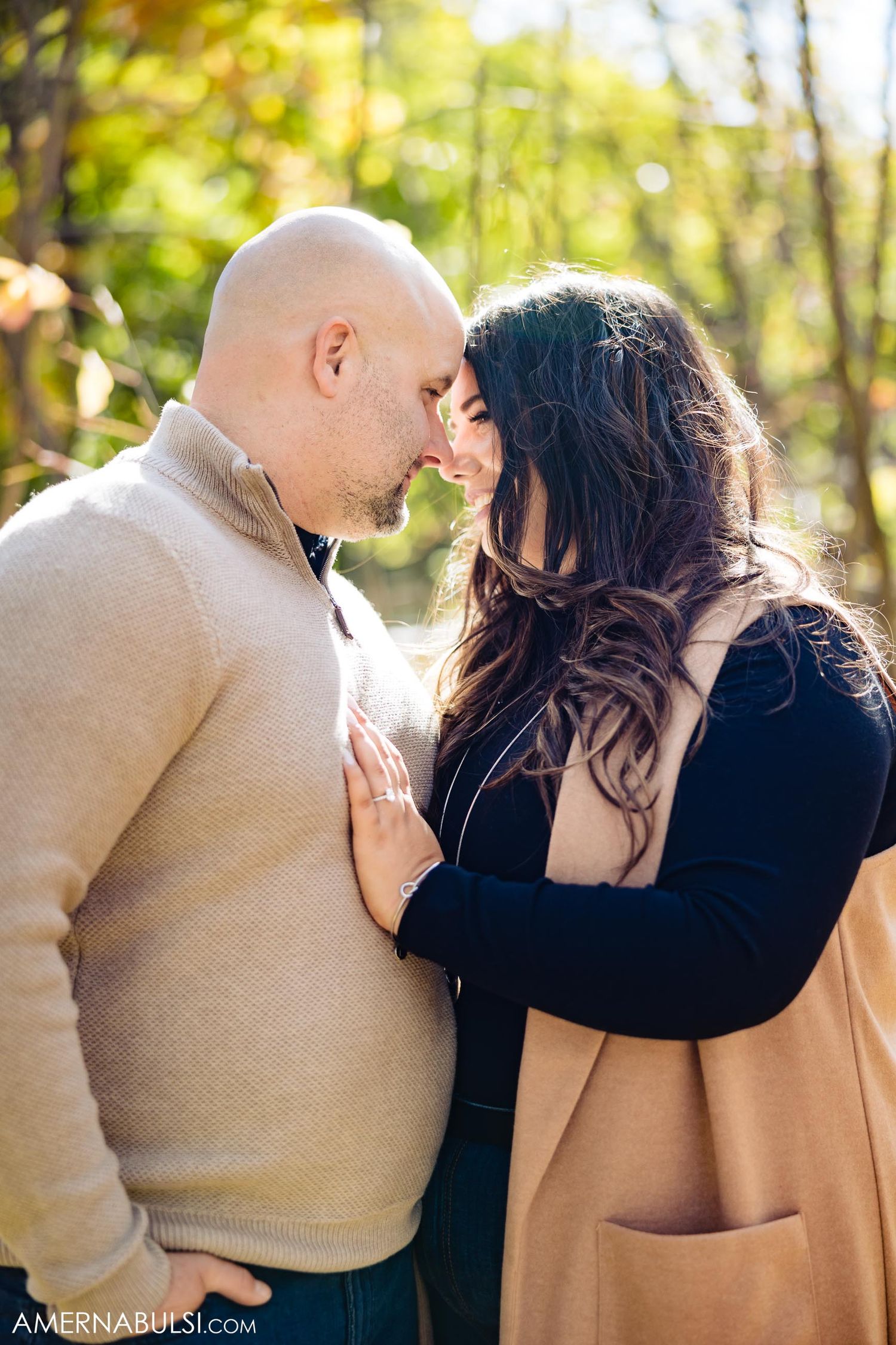 Intimate moment between couple in autumn setting with golden light.