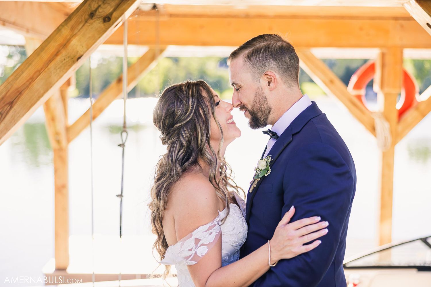A romantic outdoor wedding moment captured beneath a rustic wooden pergola.