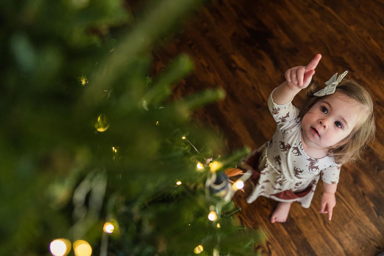 Whimsical nighttime portrait with glowing fairy lights creating magical bokeh effect in dark setting.