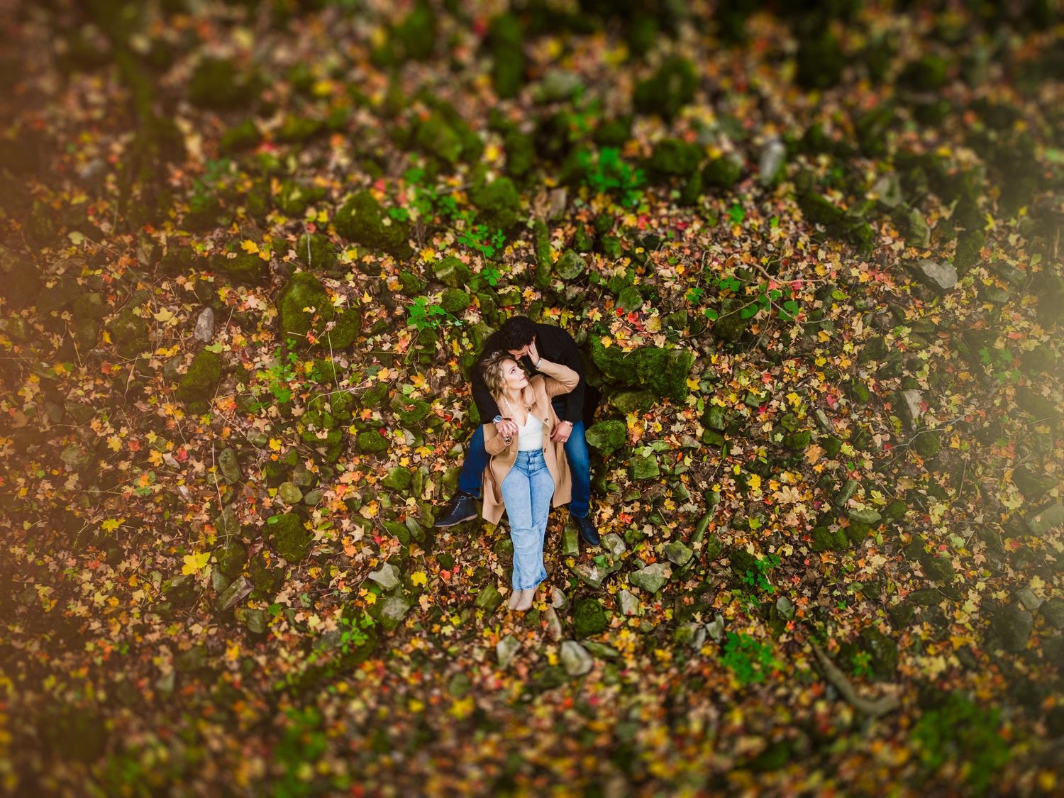 Wedding couple poses in a field of wildflowers at sunset.