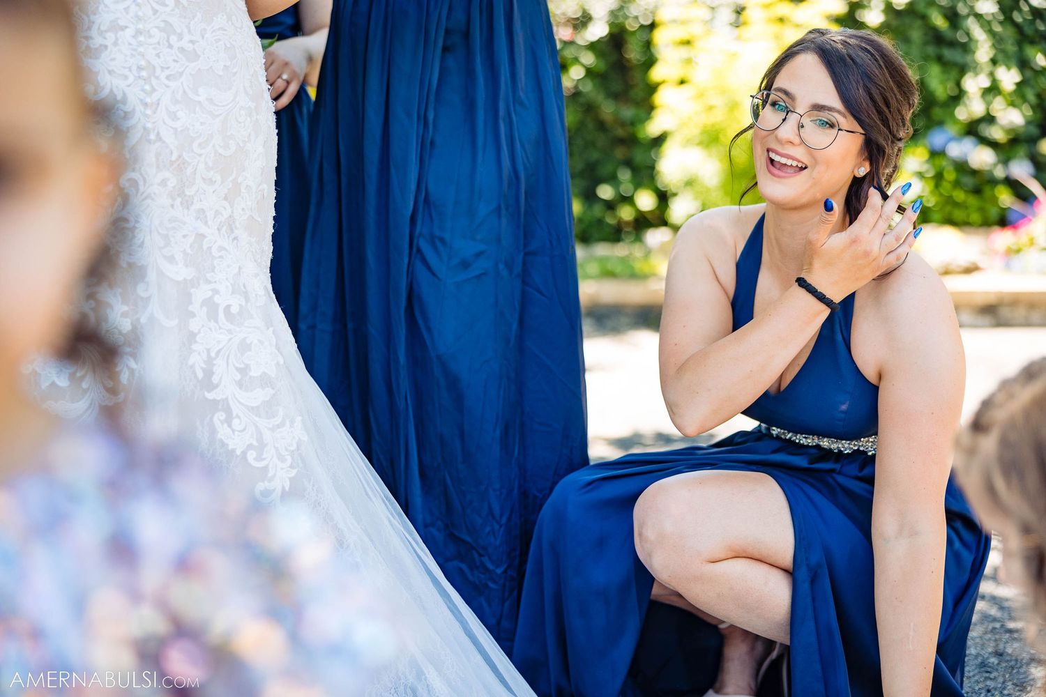 Wedding party member in navy blue dress reacting joyfully during celebrations.