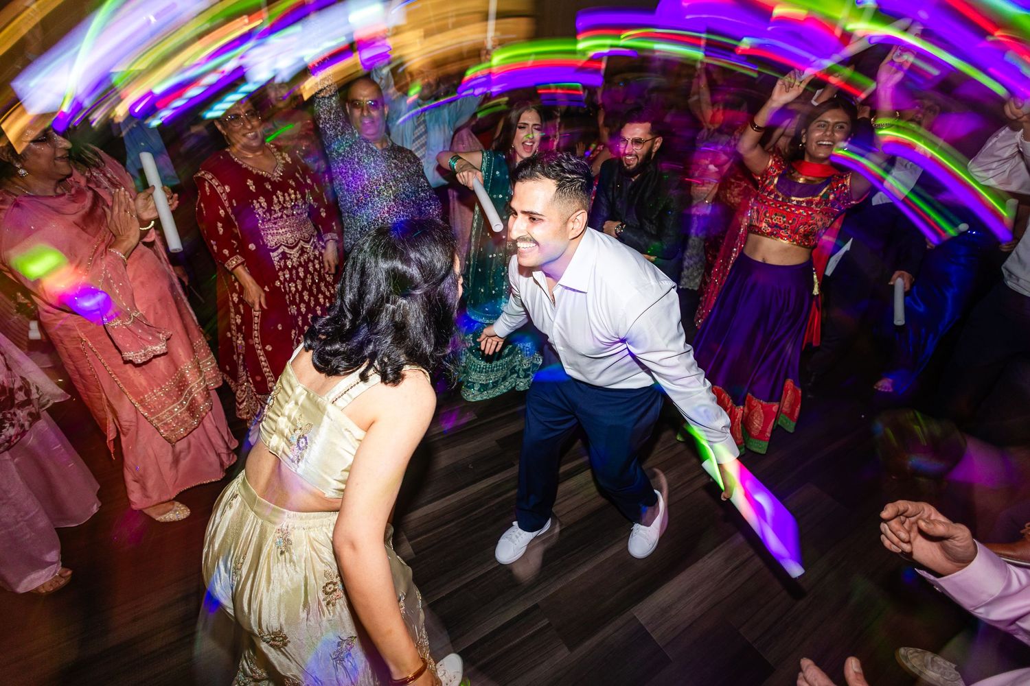 People dancing and enjoying themselves at a vibrant nightclub with colorful neon lights and energetic atmosphere.