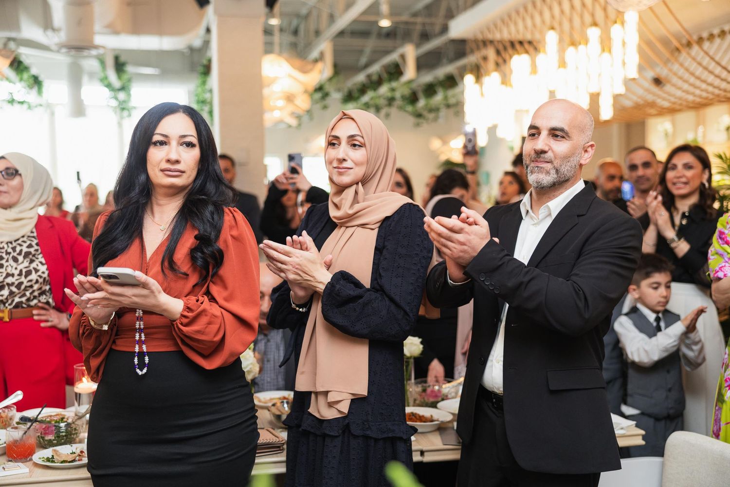 Wedding guests celebrating and taking photos during a reception event.
