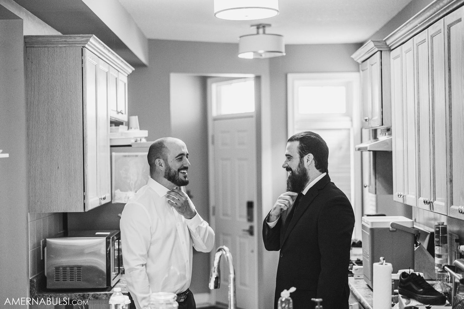 Two people in formal attire having a casual conversation in a bright indoor space.
