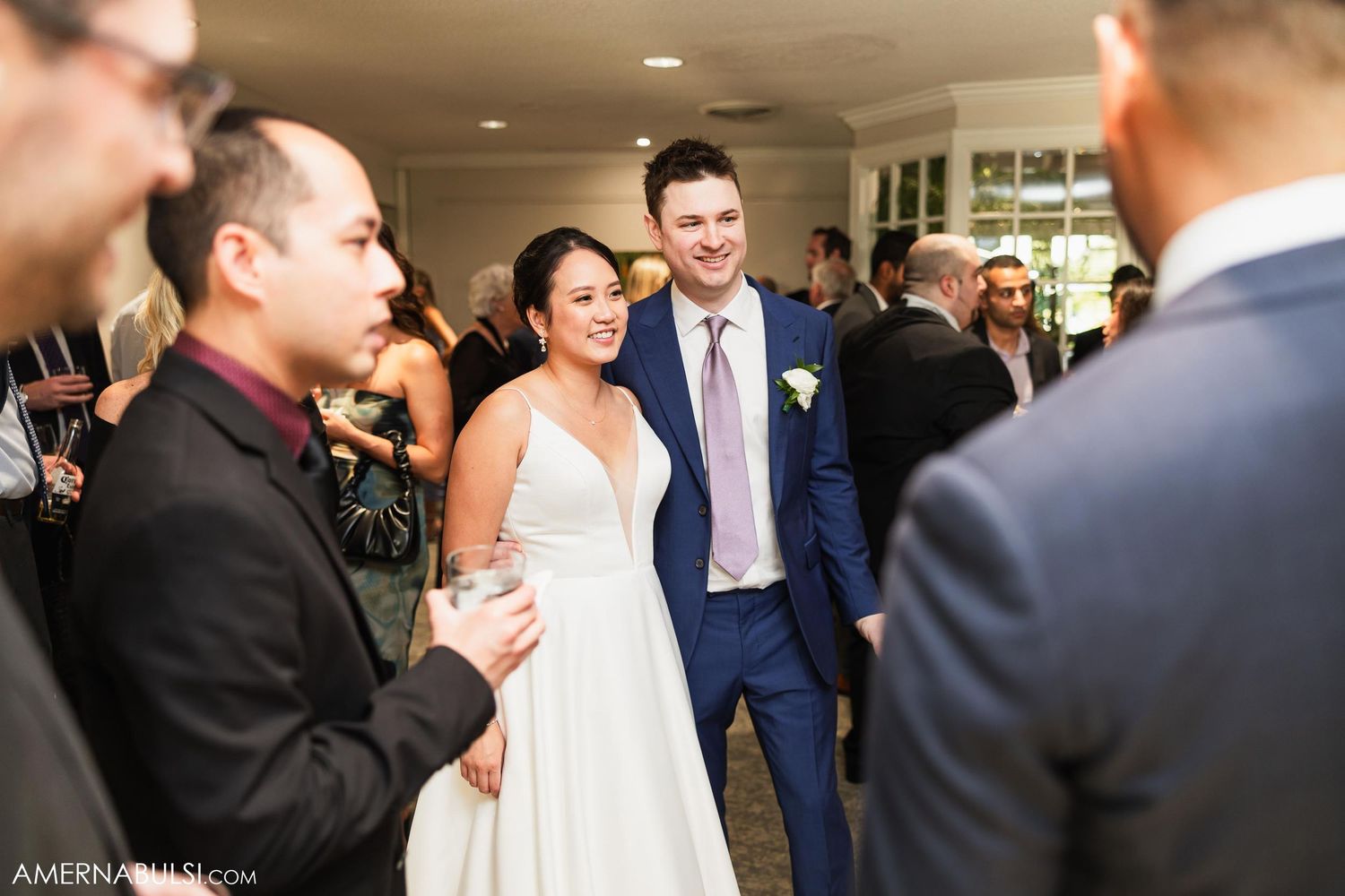 Wedding celebration with guests gathered in conversation during the reception.