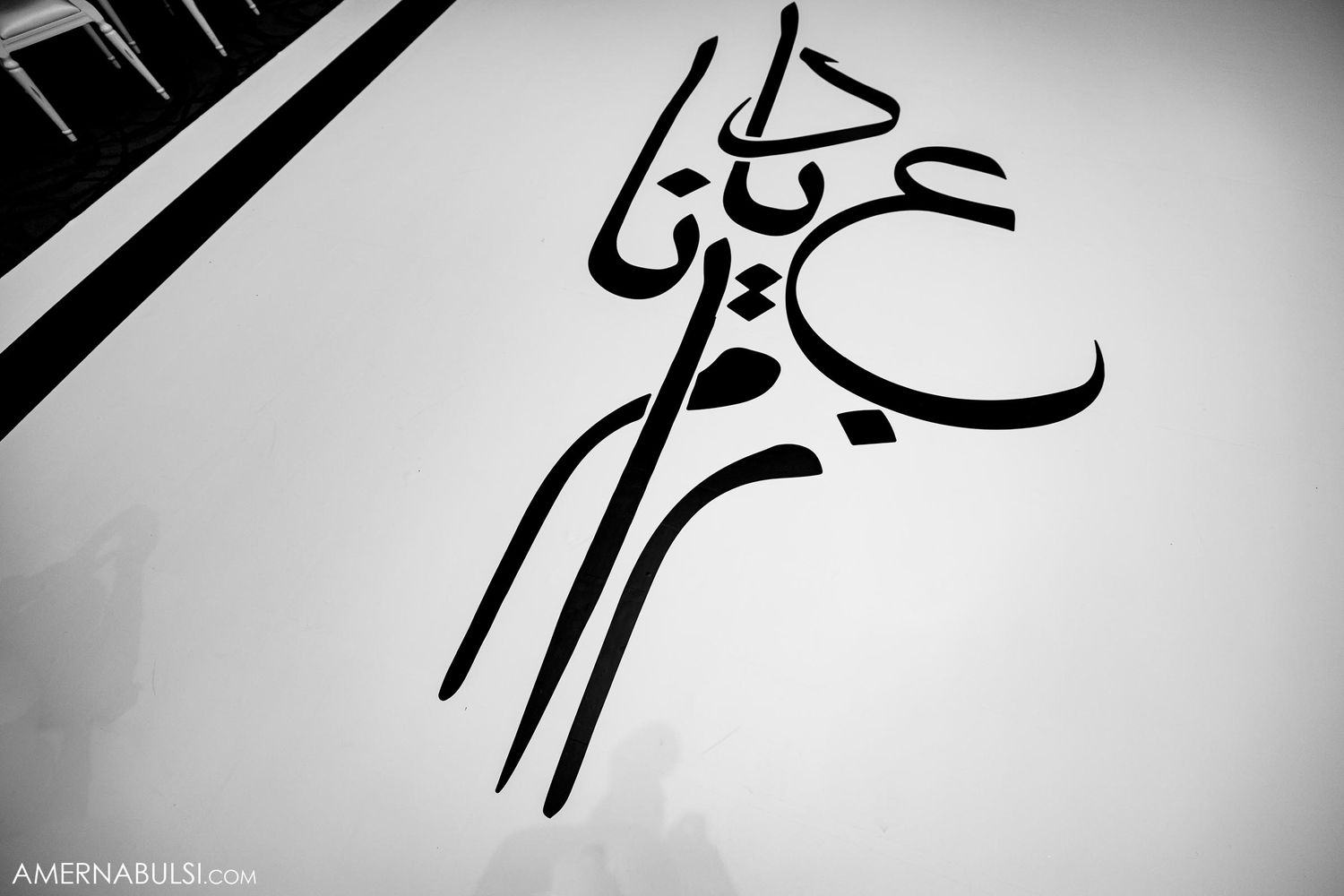 Artistic black and white calligraphy design in Arabic style.