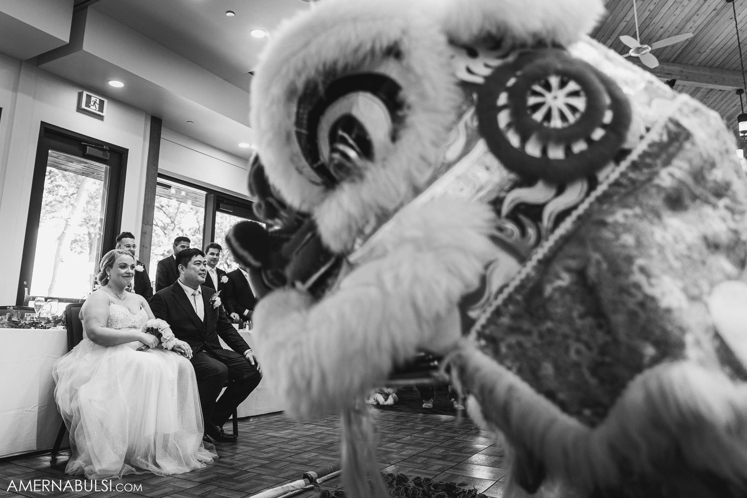 Traditional lion dance performance entertains seated wedding guests during reception.