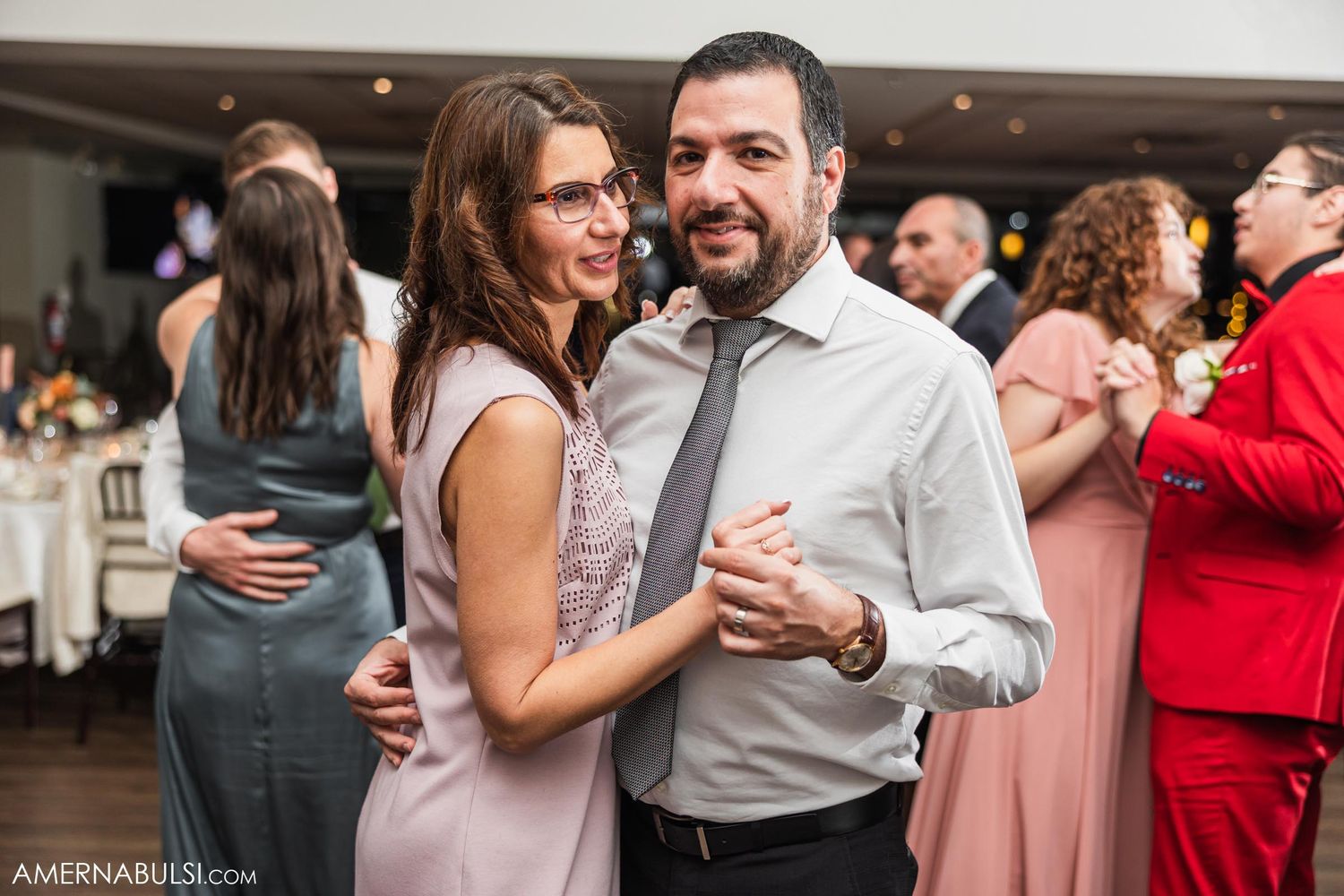 A couple shares a dance at a wedding reception.