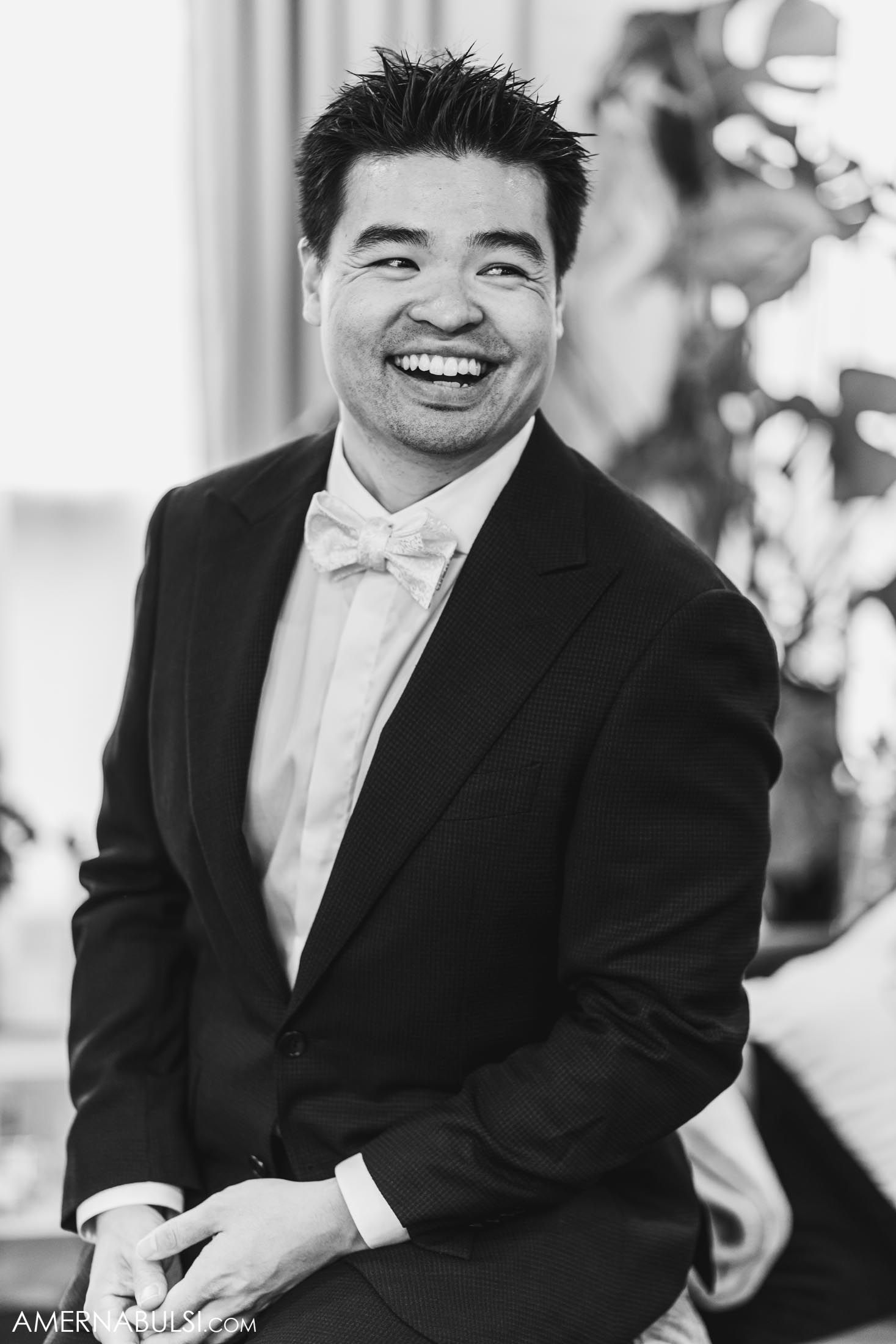 Formal portrait in black and white of someone wearing a tuxedo with bow tie.
