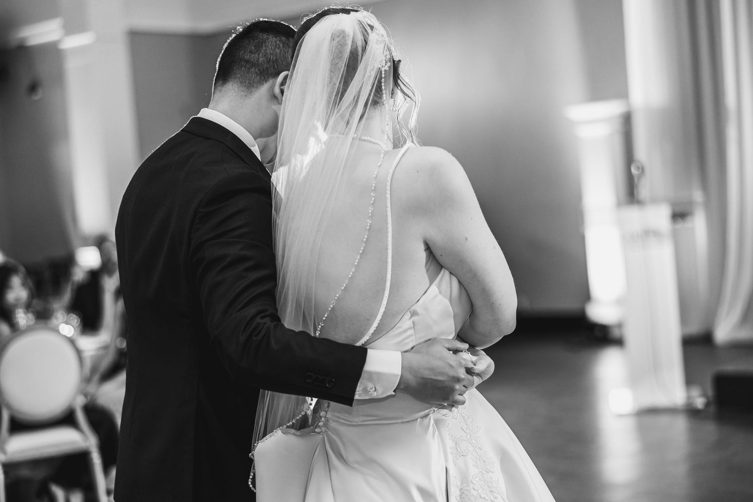 Black and white photo of bride and groom sharing an intimate slow dance at their wedding.
