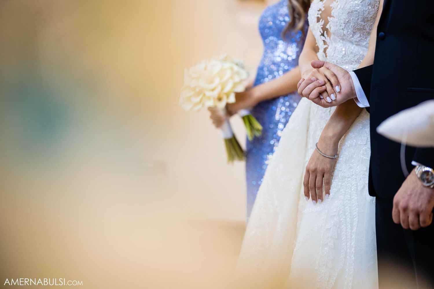 Close up of wedding dress and bouquet details during ceremony.