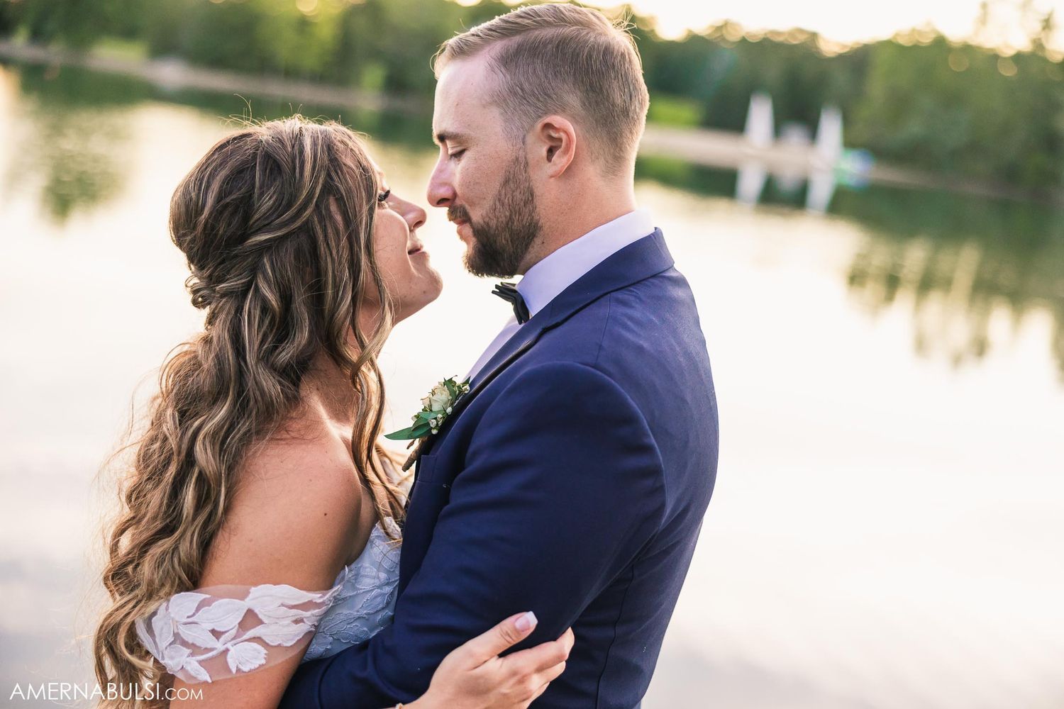 A romantic waterfront portrait with a lake and dock in the background.