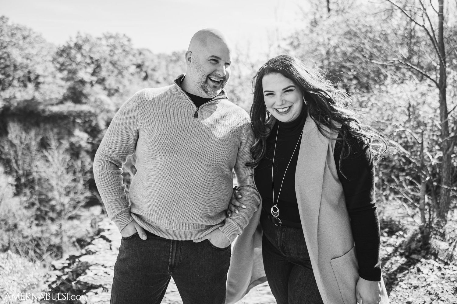 Black and white candid portrait showing joyful laughter against autumn backdrop.