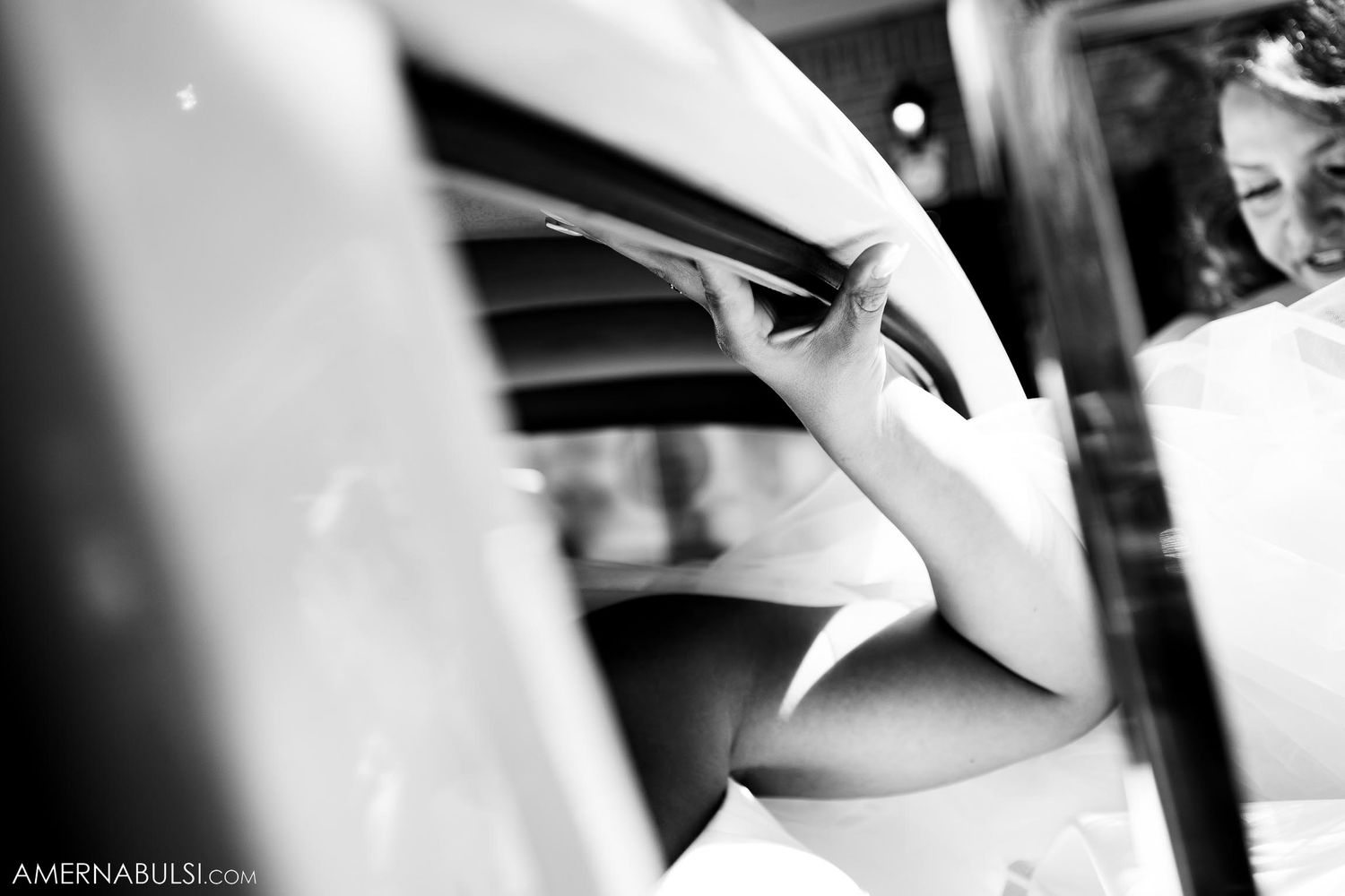 Artistic black and white detail shot of car hood ornament with reflections.