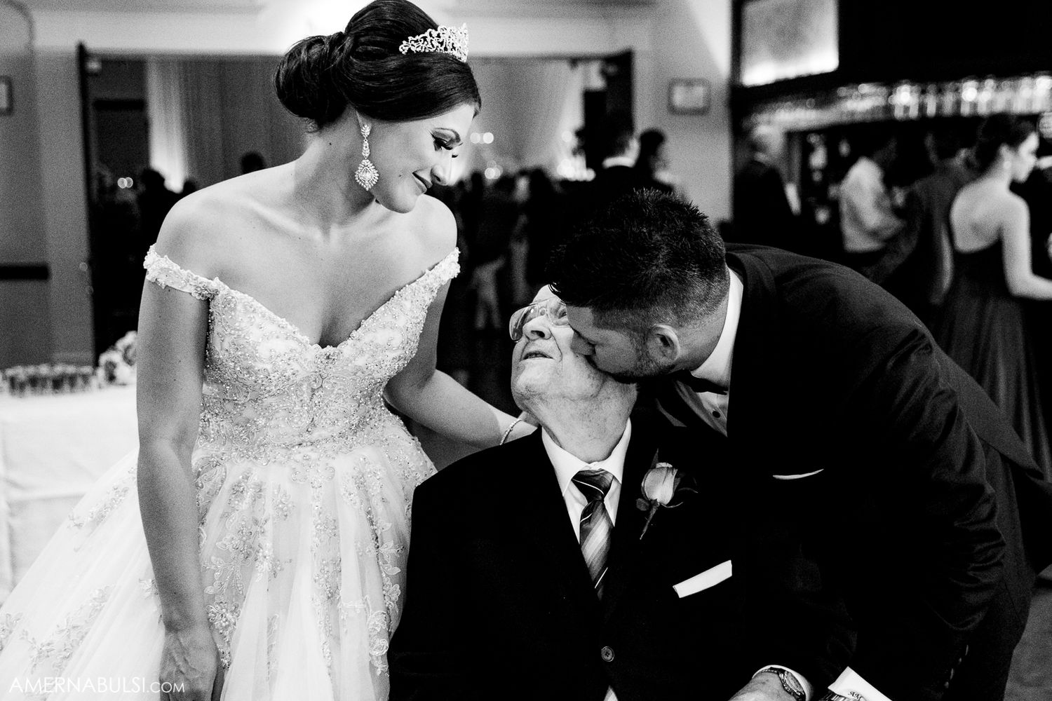 Wedding reception guests in formal attire dancing and celebrating in black and white.