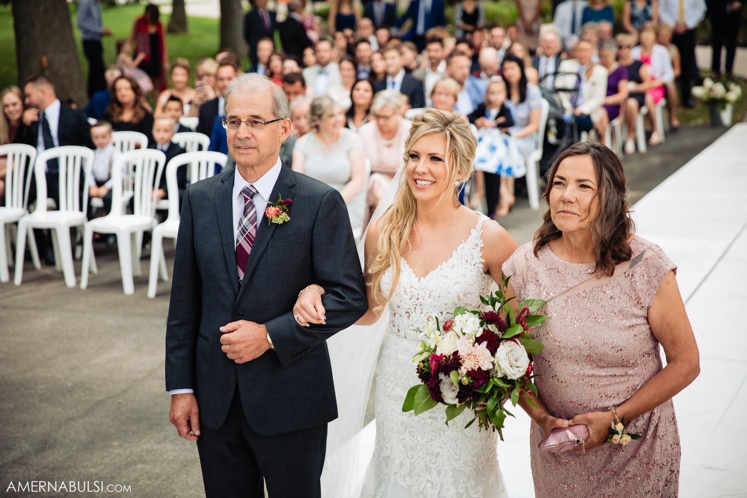 Large group of wedding guests gathered outdoors for a celebratory photo.