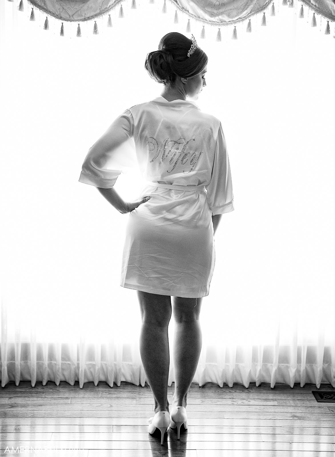 Black and white photo series showing someone in a white t-shirt dancing in front of curtained windows.