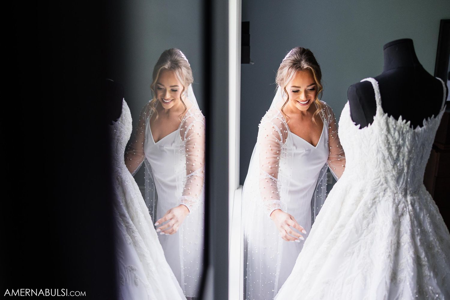 A white wedding dress on display is reflected in a mirror creating a symmetrical composition.