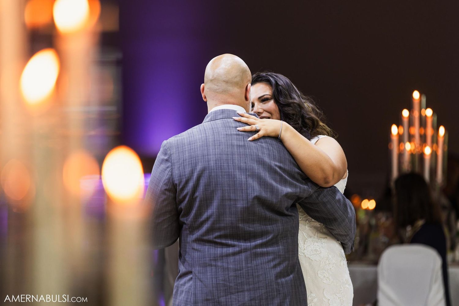 An intimate slow dance moment captured with warm candlelight in the background.