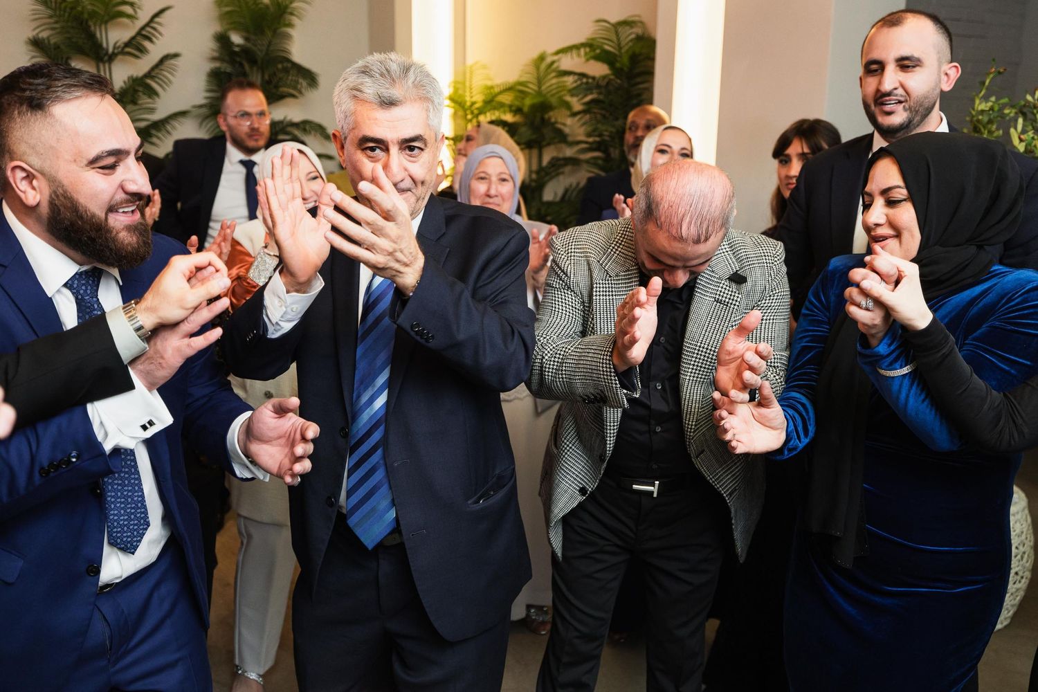 Group of wedding guests reacting with excitement and surprise.